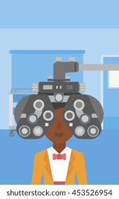 An african-american woman undergoing an eye examination while visiting optometrist at the medical office. Vector flat design illustration. Vertical layout.
