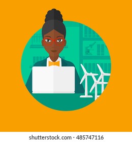 An african-american woman working in office with laptop and model wind turbines on the table. Concept of green energy. Vector flat design illustration in the circle isolated on background.