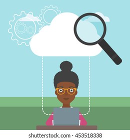 An african-american young business woman working on a laptop and cloud, magnifier and gears above her. Cloud computing concept. Vector flat design illustration. Square layout.