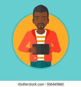 An african-american young man holding a tablet computer. Student working on tablet computer. Smiling man with digital tablet. Vector flat design illustration in the circle isolated on background.