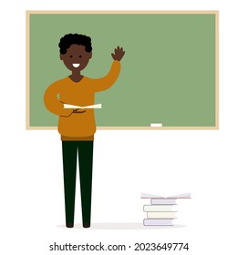 Africo American man at the blackboard with a book in his hand.