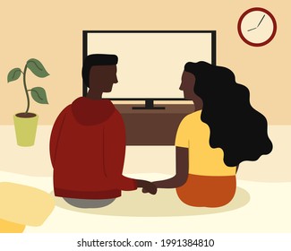 An afro american couple is sitting together on the sofa in the room and holding each other's hands