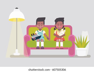 Afro american twins sitting on sofa at cozy home