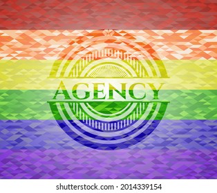 Emblema de la agencia sobre fondo de mosaico con los colores de la bandera LGBT. 