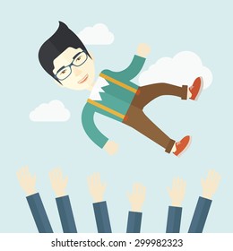 An aggressive japanese businessman being throwing up to the sky by his teamwork or colleague. Happiness concept. A contemporary style with pastel palette soft blue tinted background with desaturated