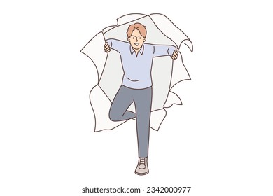 Aggressive man breaks through hole in torn paper, not paying attention to obstacles in achieving goals. Purposeful guy with aggressive grimace looks at screen, wanting to achieve success at any cost.