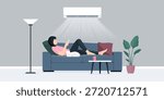 Air conditioning split system at home and Chinese woman relaxing on the couch, she is using the AC remote control