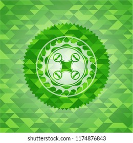 air drone icon inside green emblem with mosaic background