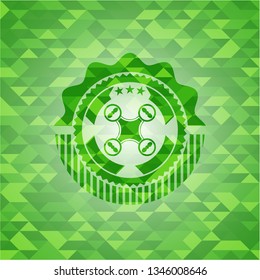 air drone icon inside green emblem with triangle mosaic background