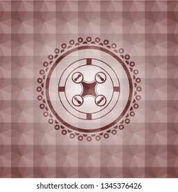 air drone icon inside red seamless emblem with geometric pattern.