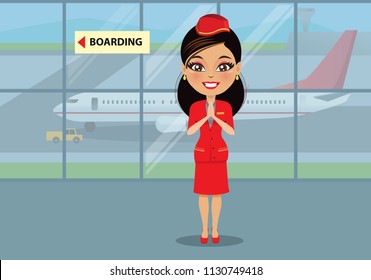 An air hostess in her uniform is at an airport guiding passengers to the boarding place. There is an aeroplane in the background on a runway.