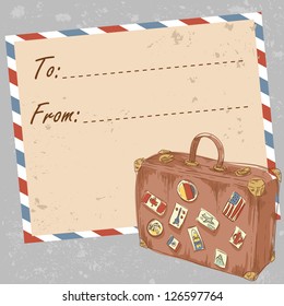Air mail travel postcard with old grunge envelope and suitcase covered with stickers from different countries