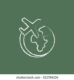 Airplane flying around the world hand drawn in chalk on a blackboard vector white icon isolated on a green background.