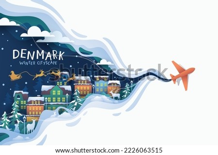 Airplane flying to denmark landmark over city buildings in winter 