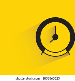 alarm clock with drop shadow on yellow background