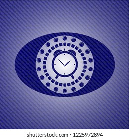 alarm clock icon inside badge with denim background