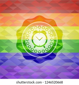 alarm clock icon inside emblem on mosaic background with the colors of the LGBT flag