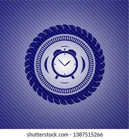 alarm clock icon inside emblem with jean background