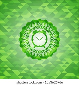 alarm clock icon inside green mosaic emblem