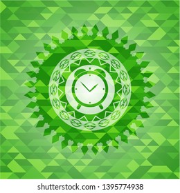 alarm clock icon inside green emblem with mosaic background