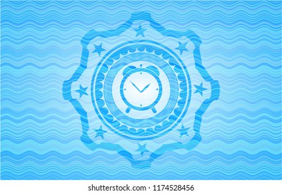 alarm clock icon inside light blue water style emblem.