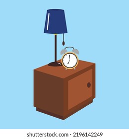 Alarm clock and table lamp on the pedestal