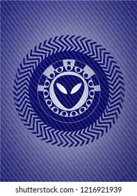 alien icon inside badge with denim background