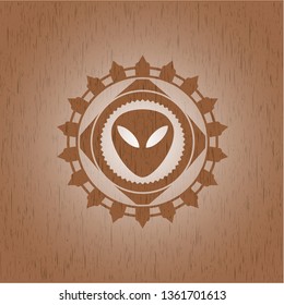alien icon inside badge with wood background