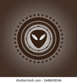 icono alienígena dentro de la placa con fondo de madera