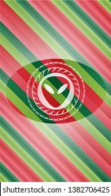 alien icon inside christmas colors style badge.