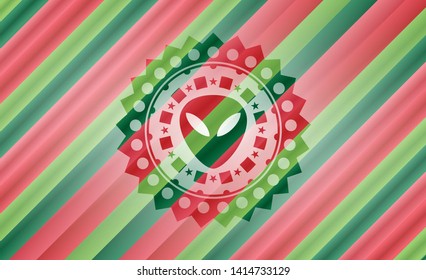 alien icon inside christmas style badge..