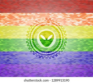 alien icon inside emblem on mosaic background with the colors of the LGBT flag