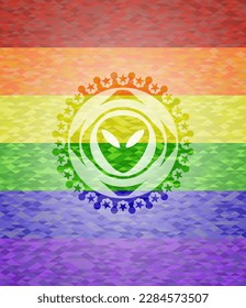 alien icon inside emblem on mosaic background with the colors of the LGBT flag. 