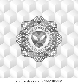 alien icon inside grey emblem with cube white background