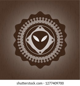 alien icon inside retro style wooden emblem