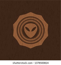 alien icon inside retro wooden emblem