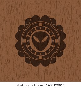 alien icon inside retro wooden emblem