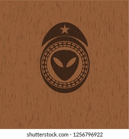 alien icon inside wood badge or emblem