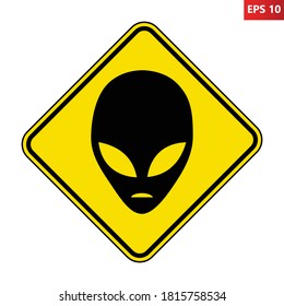 Aliens warning road sign. Vector illustration of yellow diamond shaped traffic sign with black alien head icon inside. Caution UFO activity area. Alien abduction symbol.