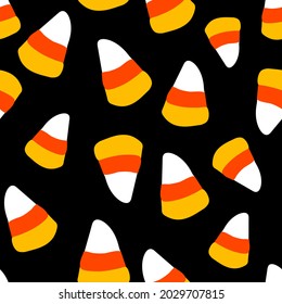 All over Halloween seamless vector repeat pattern with candy corn tossed on black background