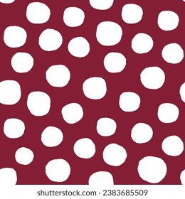 All over seamless repeat pattern with hand drawn irregular white polka dot on deep burgundy maroon. Traditional trendy modern xmas background with tossed dots