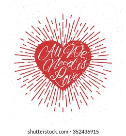 'All We Need is Love' vintage grunge hand lettering with red sparkling heart for t-shirt apparel, print, poster, card design etc. Vector Illustration.