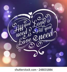 All you need is love. Calligraphic lettering with bokeh lights.