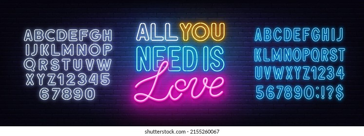 All you need is love neon lettering on brick wall background.