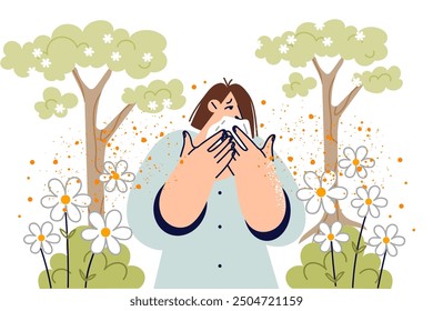 Allergy to spring flower pollen in woman using handkerchief, standing in park among trees. Problem of allergy and respiratory tract irritation due to negative impact of allergen on health