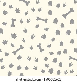 Allover seamless repeat pattern with different shape gray dinosaur tracks and bones tossed on an ivory background