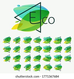 Alphabet in triangle frame at green leaves watercolor background. Vector ecology typeface for botanical labels, landscape headlines, recycle posters, organic cards etc.