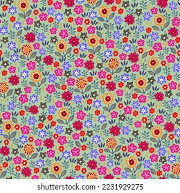 Amazing seamless floral pattern with bright multicolored flowers and leaves on a green background. An elegant template for fashionable prints. Modern floral background. Folk style.