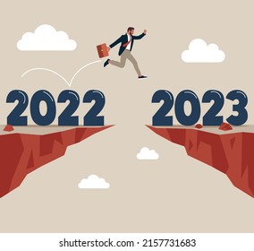 Un empresario ambicioso salta con el paso del año de 2022 a 2023. Año 2023 esperanza, resolución de año nuevo u oportunidad de éxito, cambio a un nuevo futuro de negocios brillante, superación del concepto de dificultad de negocio.