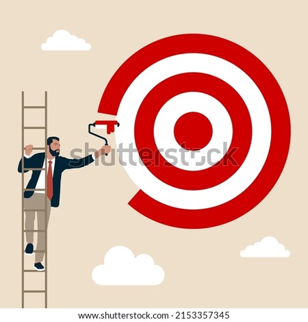 Ambitious businessman on ladder using paint roller to paint big dartboard, archery target. Purpose, set business goal or target, KPI, key performance indicator or set objective and achievement concept